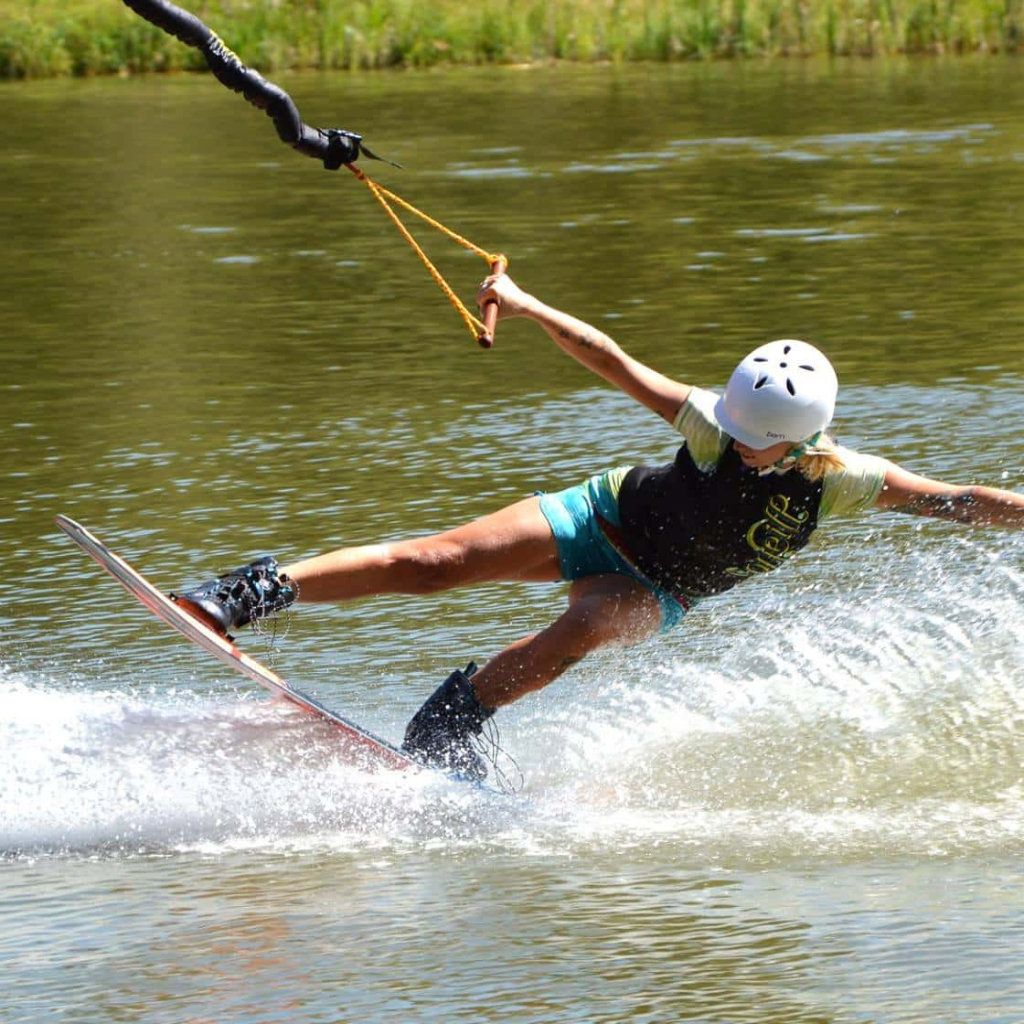 Surfař provádějící wakeboarding na vodní hladině Wakeparku Karvánky.