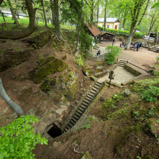 Vstup do Chýnovské jeskyně obklopený přírodou a skalními útvary.