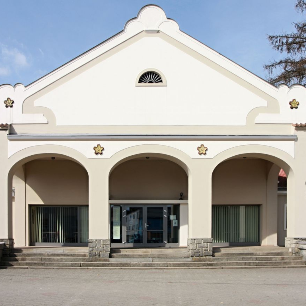 Pohled zepředu na Kino Soběslav, zobrazující hlavní vstup s třemi klenbami a elegantní architekturou.